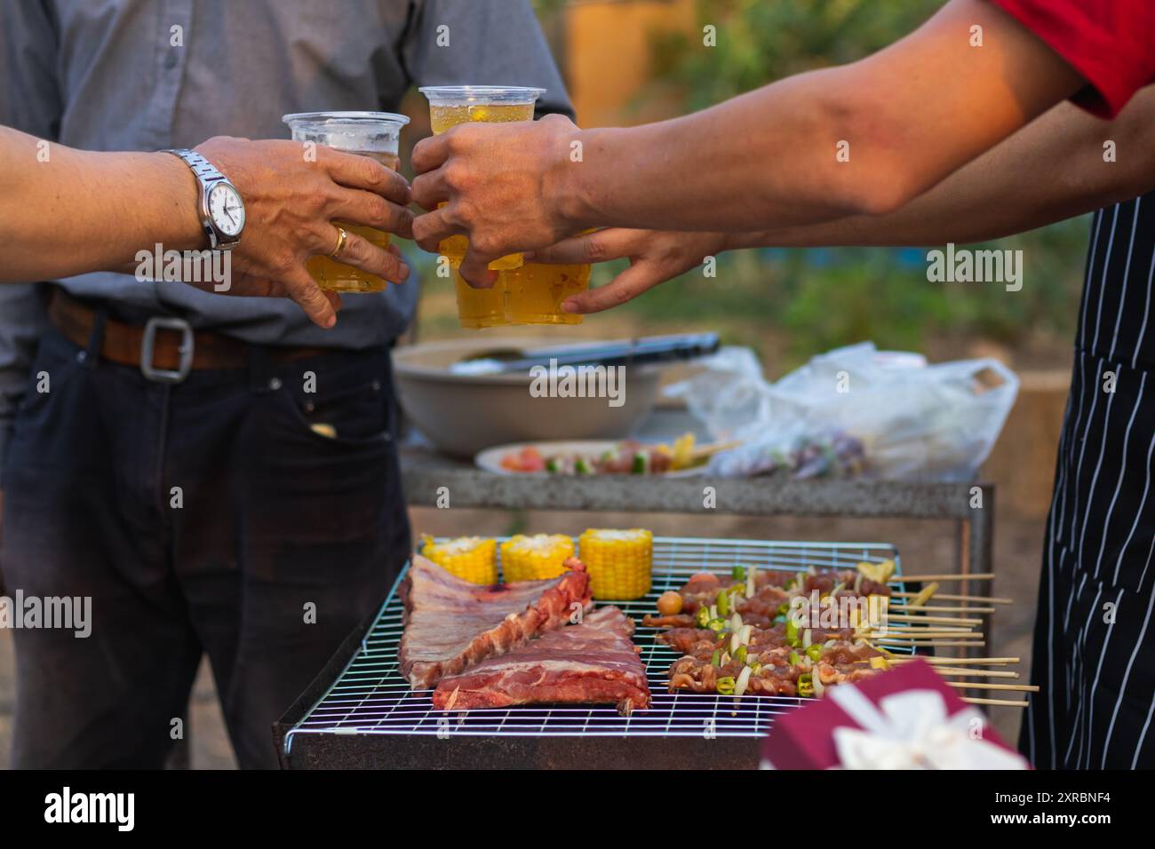 Le bevande alla birra preparate per il barbecue tra gli amici sono servite in bicchieri di plastica perché i bicchieri di plastica possono essere facilmente conservati alla fine della festa. Facile Foto Stock