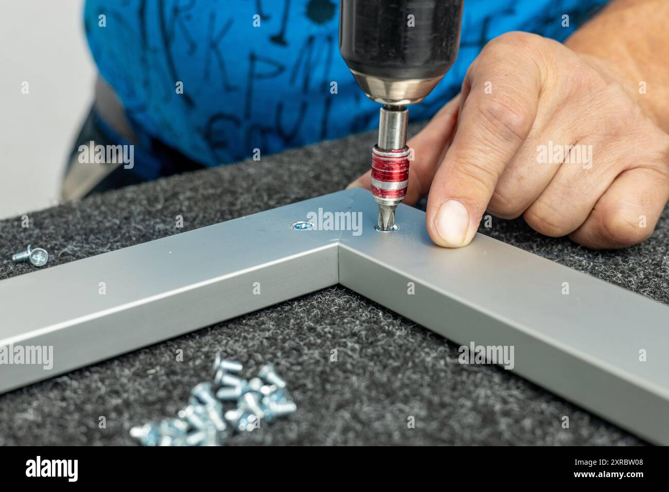 Un lavoratore assembla a mano i telai in alluminio Foto Stock