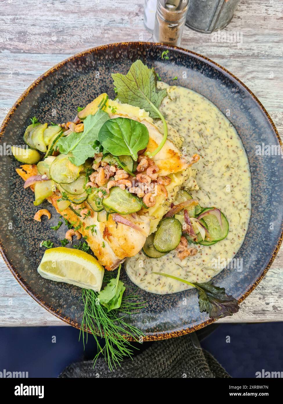 Filetto di pesce con gamberetti in salsa di senape, foglie di lattuga, fette di cetriolo, limone e aneto, servito caldo su un piatto, Prerow, Germania Foto Stock