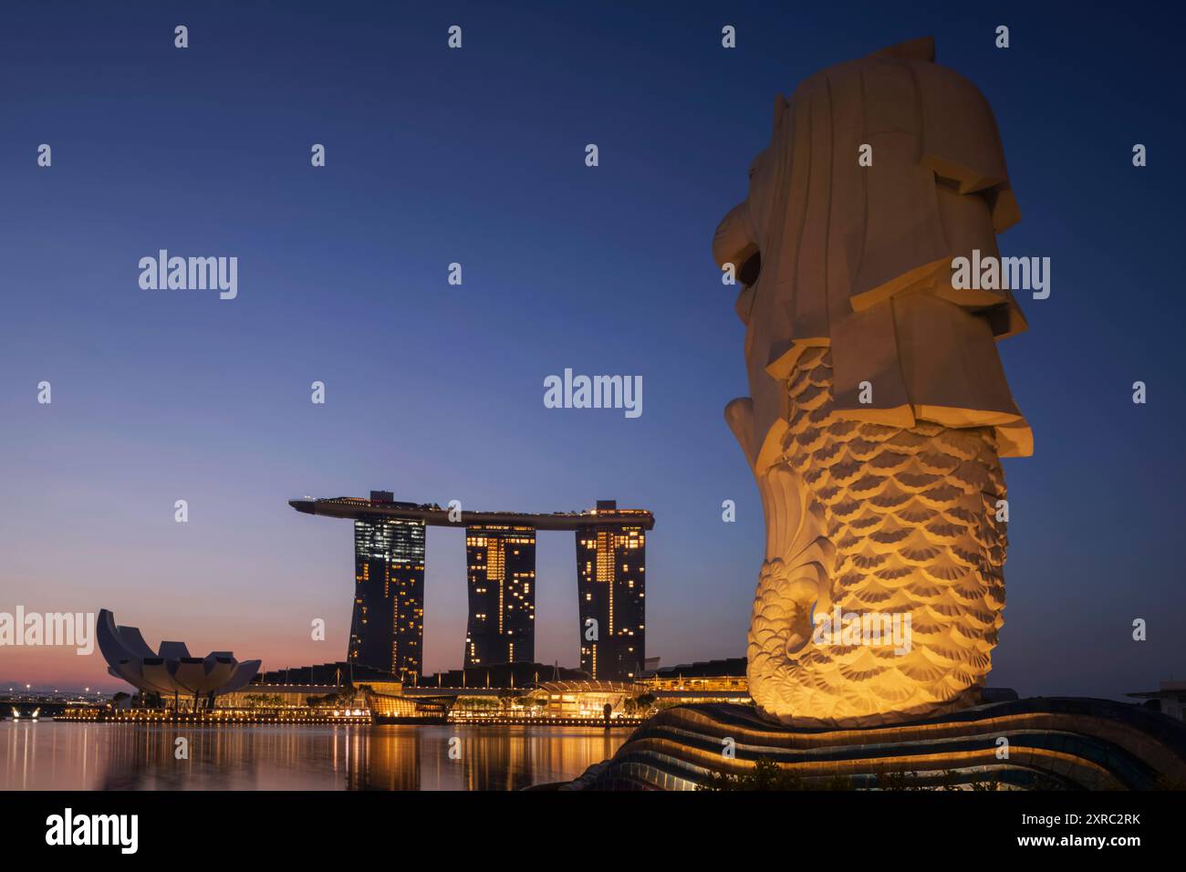 Asia, Singapore, la statua del Merlion e il Marina Bay Sands Hotel at Dawn Foto Stock