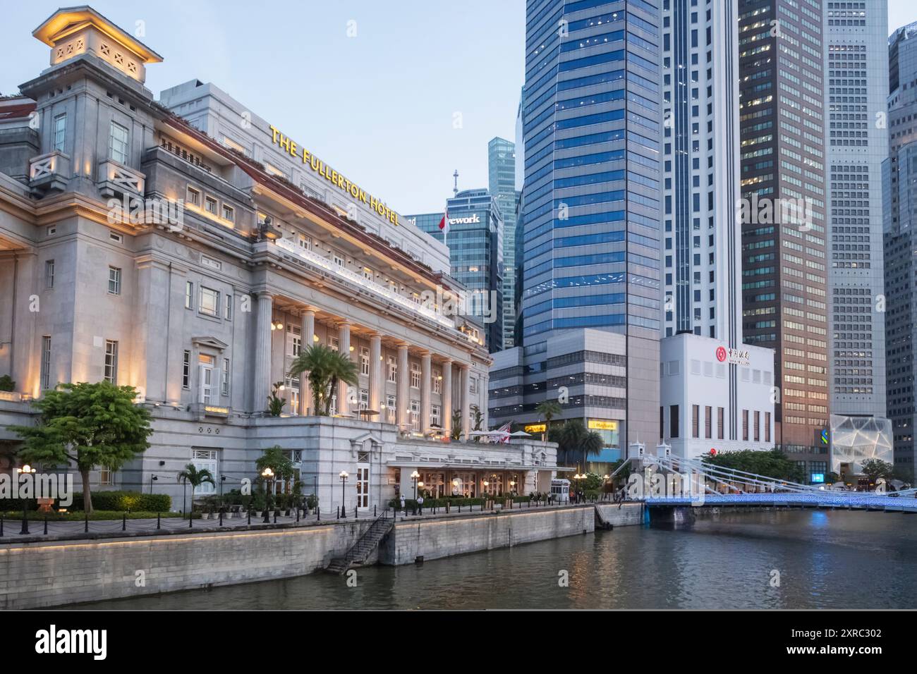 Asia, Singapore, Singapore River e gli edifici degli uffici dell'hotel Fullerton e della zona commerciale della città a Dusk Foto Stock