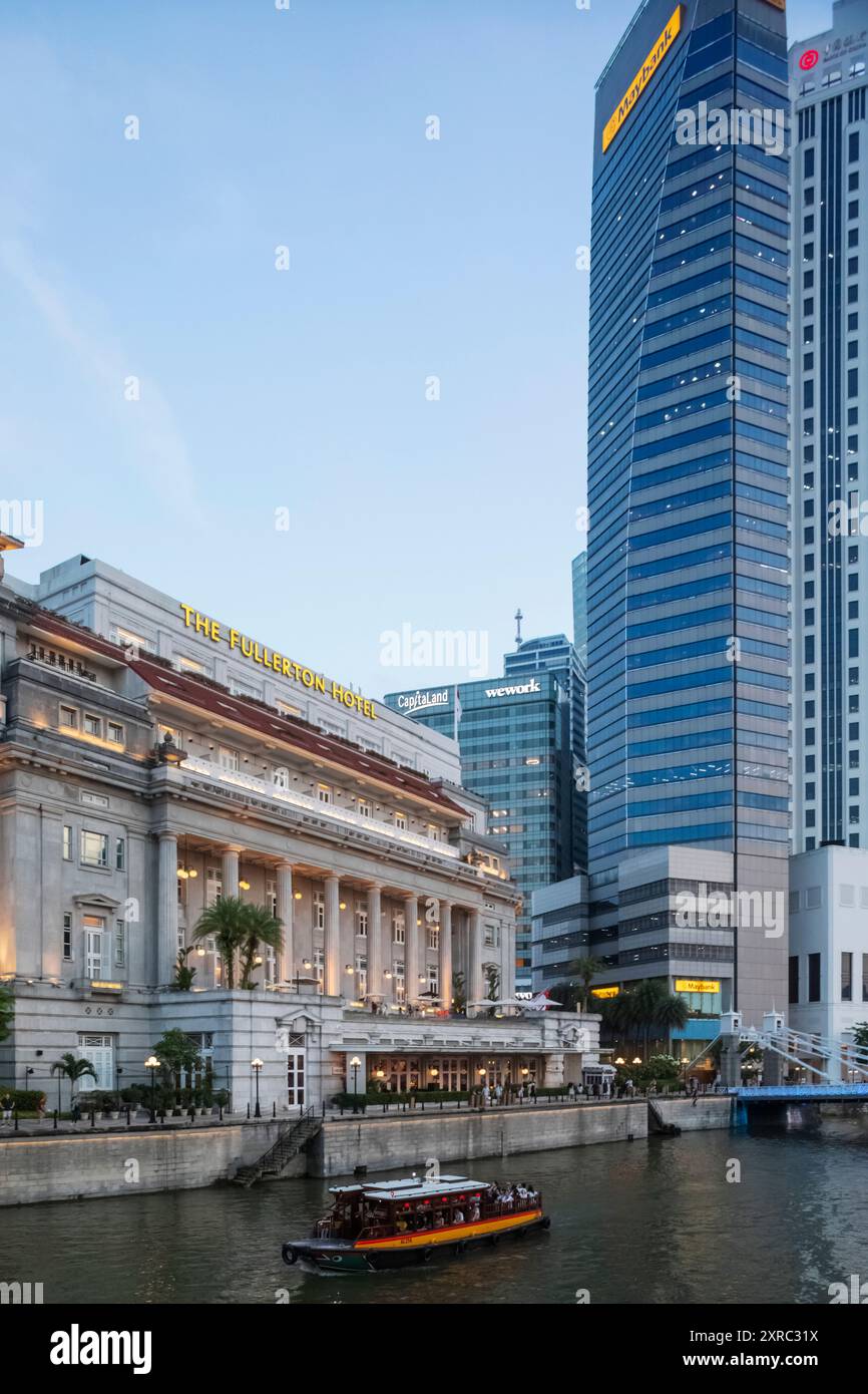Asia, Singapore, Singapore River e gli edifici degli uffici dell'hotel Fullerton e della zona commerciale della città a Dusk Foto Stock