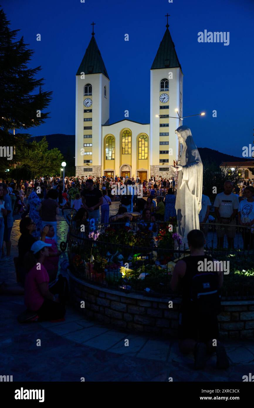 La gente prega intorno alla statua della Regina della Pace vicino alla Chiesa di San Giacomo a Medjugorje, Bosnia-Erzegovina. Foto Stock