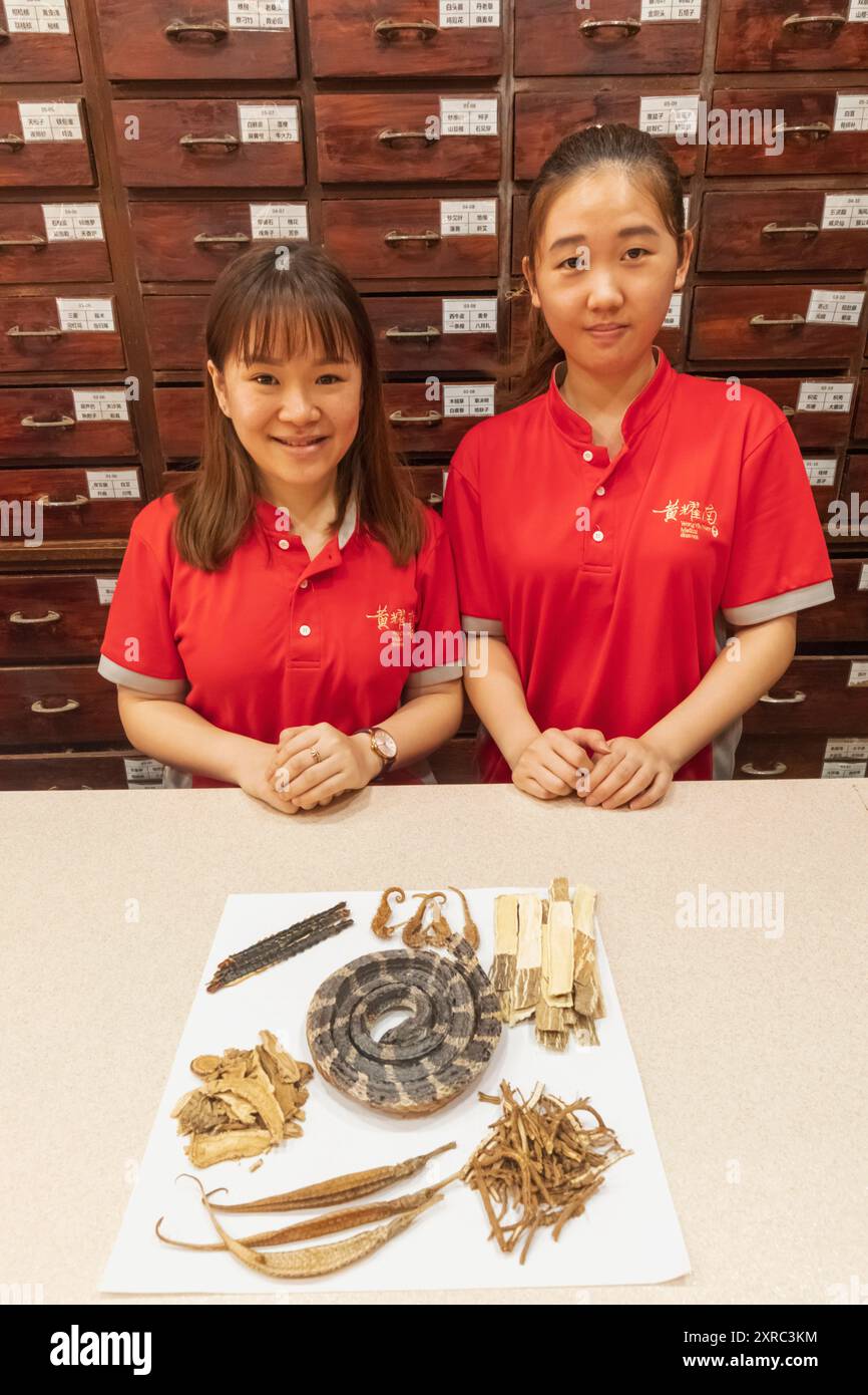 Asia, Singapore, Chinatown, Chinese Herbal Medicine Store, Sales Girls con esposizione di prodotti Herbal Medicine Foto Stock