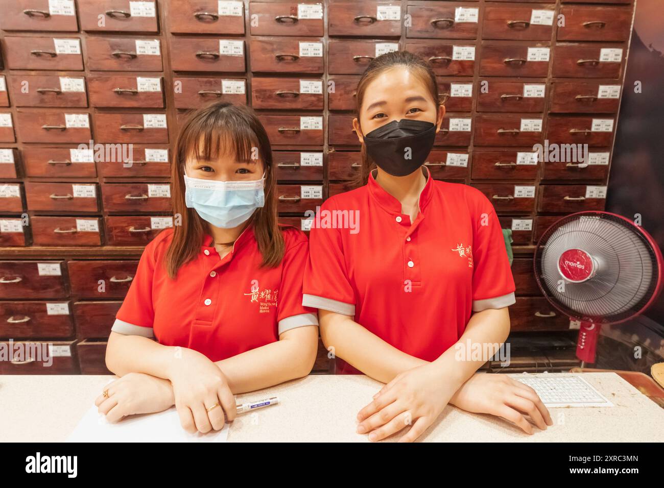 Asia, Singapore, Chinatown, Chinese Herbal Medicine Store, Sales Girls con esposizione di prodotti Herbal Medicine Foto Stock