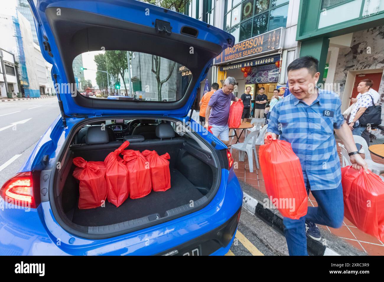 Asia, Singapore, cibo da asporto cinese caricato nel bagagliaio dell'auto Foto Stock