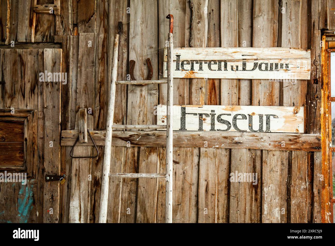 Vecchi segni di legno di un ex parrucchiere nel capannone Foto Stock