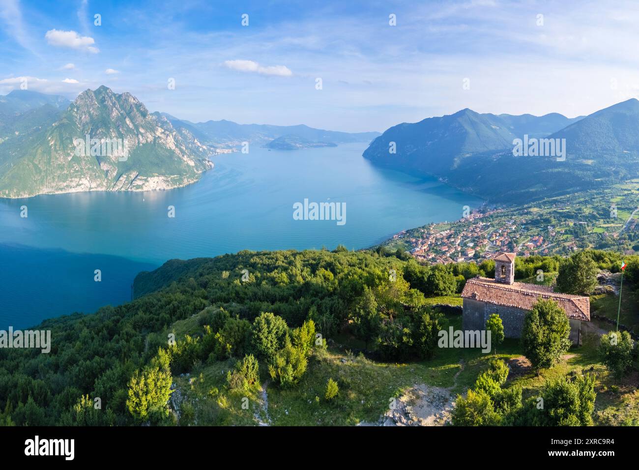 Veduta aerea della chiesetta di San Defendente che domina in estate il Lago d'Iseo, Solto Collina, Lago d'Iseo, Bergamo, Lombardia, Italia, Foto Stock