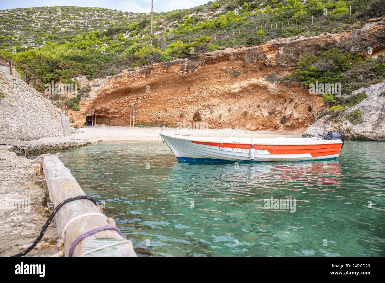 Tipico paesaggio greco, la natura mediterranea della Grecia, paesaggio girato di una baia con una barca. Crepuscolo su Zante, Isole Ionie, Grecia Foto Stock