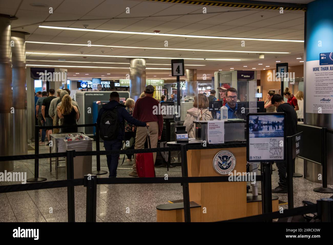 Ancoraggio, Alaska. Aeroporto internazionale Ted Stevens di Anchorage. Le persone che passano attraverso il controllo di sicurezza della TSA all'aeroporto. Foto Stock