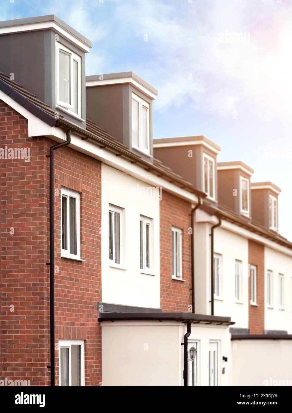 Vista dei nuovi edifici moderni a schiera con architettura residenziale contemporanea nelle soleggiate giornate estive. Sviluppo immobiliare tipico mercato immobiliare. Foto Stock