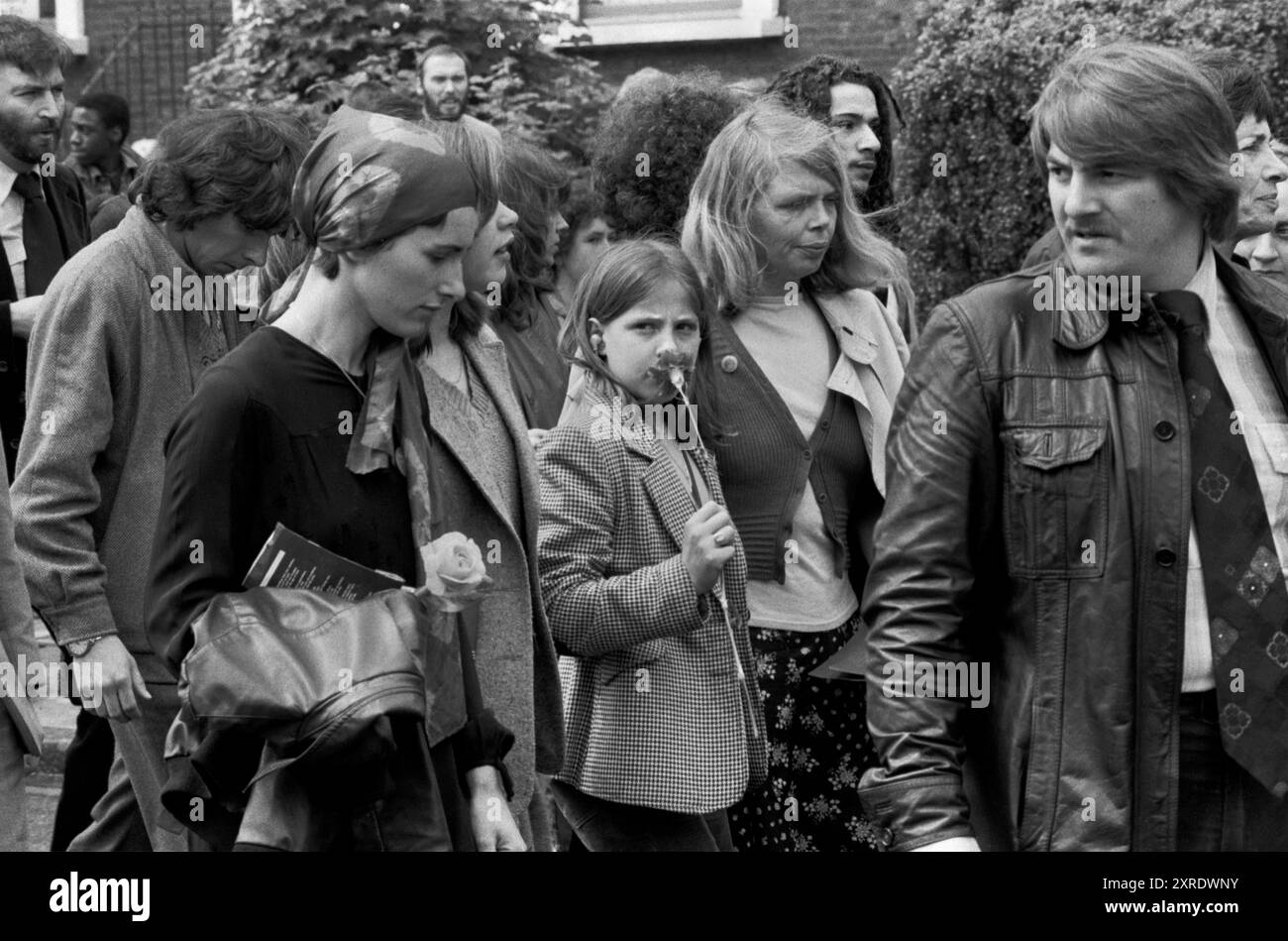 Celia Stubbs moglie di Blair Peach (capelli biondi) al funerale dei suoi partner e la loro figlia Rebecca Holding rose. Cammina in processione dietro la bara sulla rotta verso il cimitero. Southall, Londra, Inghilterra 13 giugno 1979. 1970 UK HOMER SYKES Foto Stock