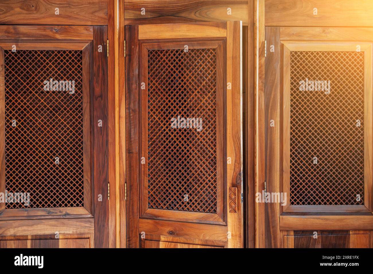 Apri la porta di legno con un reticolo alla cabina confessionale per la confessione all'interno della cattedrale cattolica Foto Stock