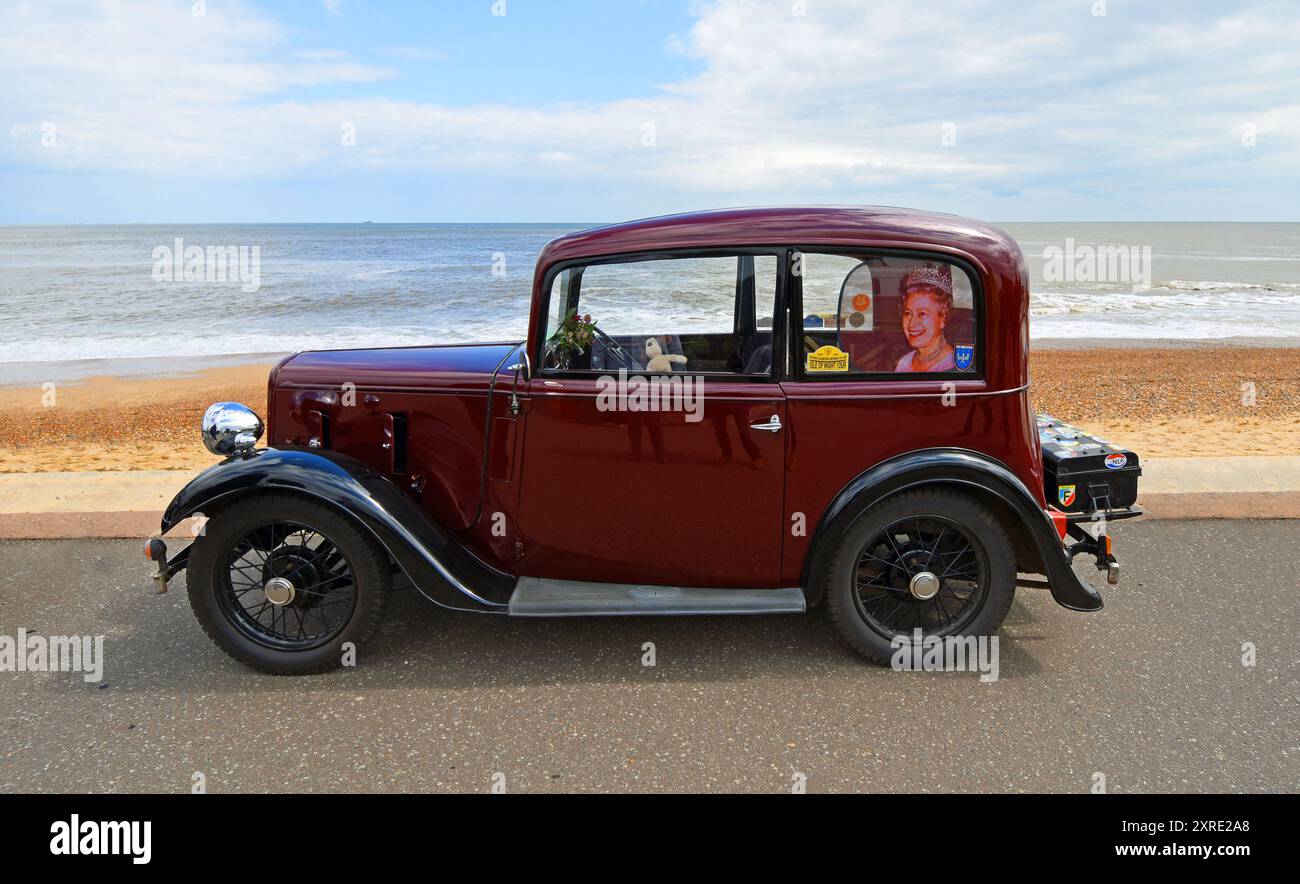 Austin Seven vintage parcheggiata sulla spiaggia lungomare e sul mare sullo sfondo. Foto Stock