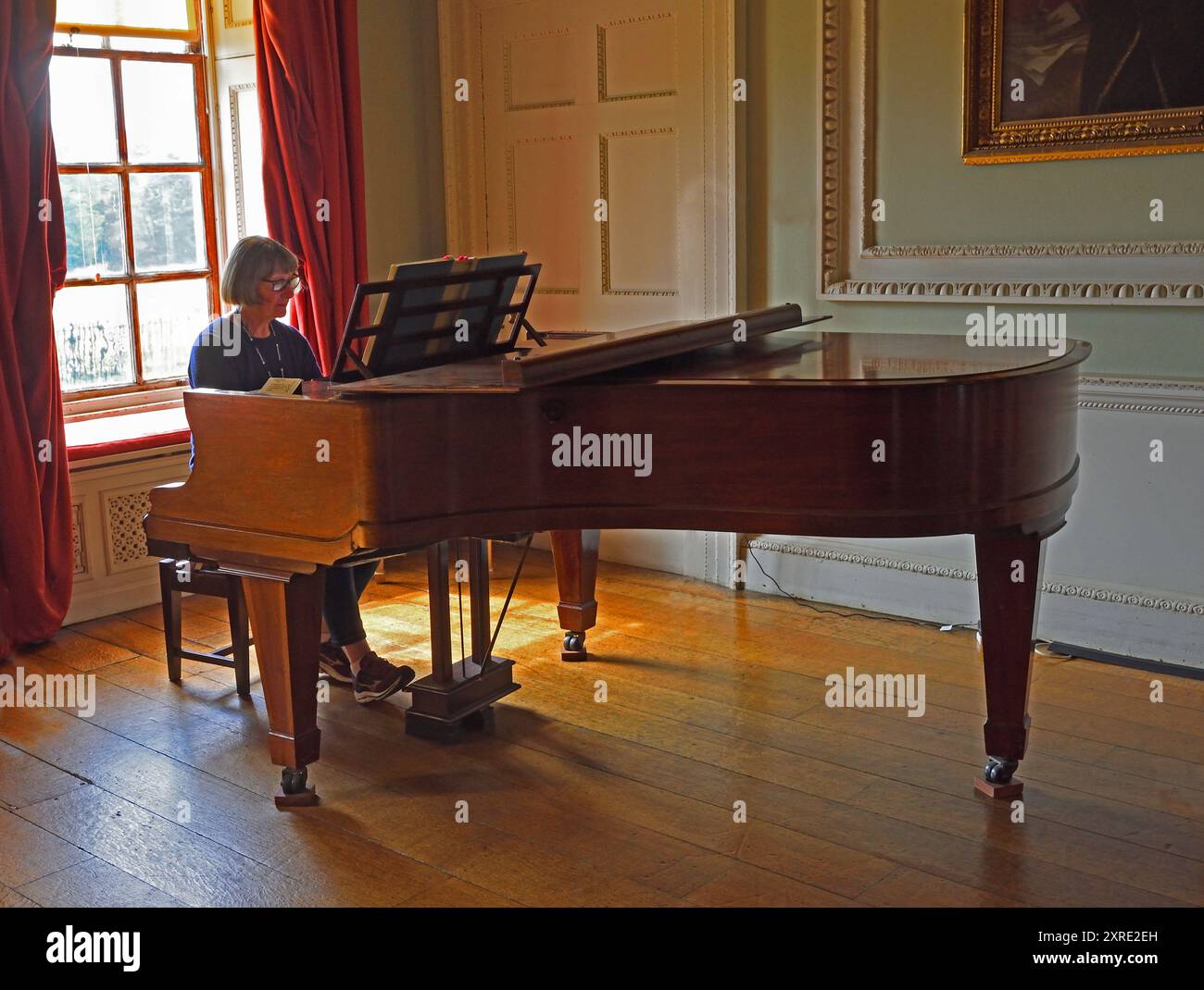 Donna che gioca a Bluthner Grand piano nella bellissima Old Room. Foto Stock