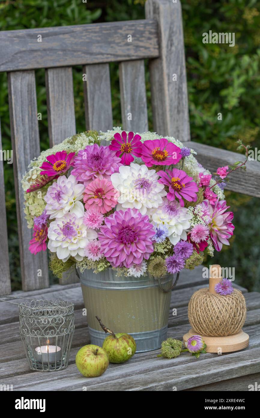 bouquet romantico con dahlias viola e bianche, zinnie, garofani e carote selvatiche in un vaso di fiori vintage in giardino Foto Stock