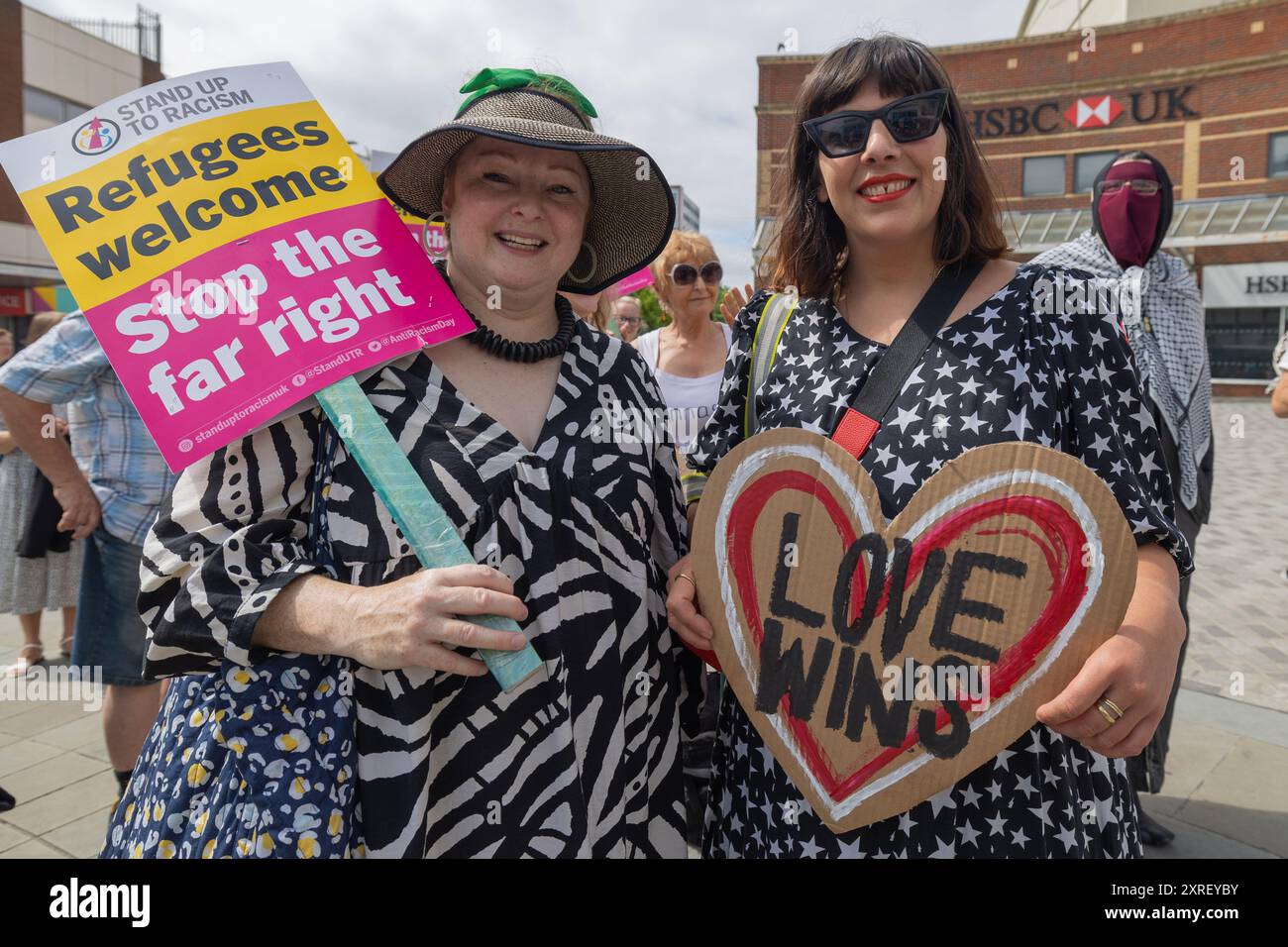Southend on Sea, Regno Unito. 10 agosto 2024. Due manifestanti hanno dei cartelli che recitano: “ALZARSI AL RAZZISMO – i rifugiati accolgono – fermare l’estrema destra” e “AMARE WINS” durante una manifestazione pubblica in una città del Regno Unito. La scena cattura temi di inclusività, antirazzismo e opposizione alle ideologie di estrema destra. Banca HSBC visibile in background. Resisti al razzismo organizza una manifestazione in cima alla High Street per dimostrare solidarietà ai richiedenti asilo, no al razzismo e all'estrema destra. Penelope Barritt/Alamy Live News Foto Stock