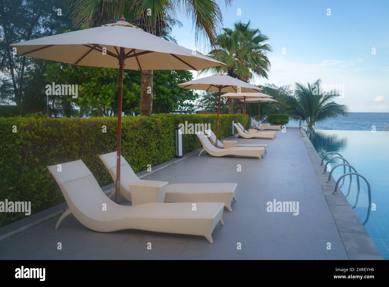 Giardino con sedie a sdraio e area salotto vicino alla piscina Foto Stock