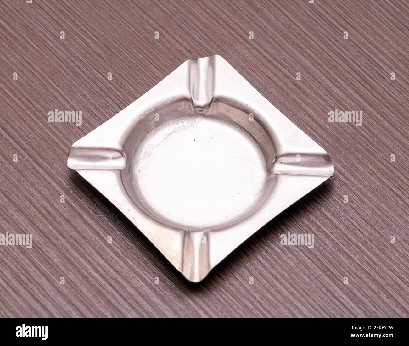 Posacenere di forma quadrata argento vuoto su un tavolo di legno Foto Stock