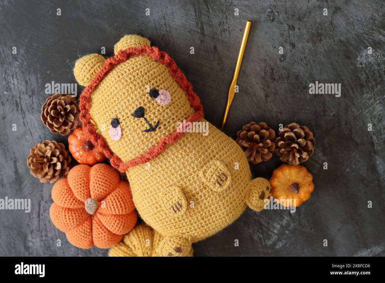 Foto ravvicinata del giocattolo morbido Lion all'uncinetto. Simpatico tappeto fatto a mano su sfondo scuro con spazio per le copie. Foto Stock