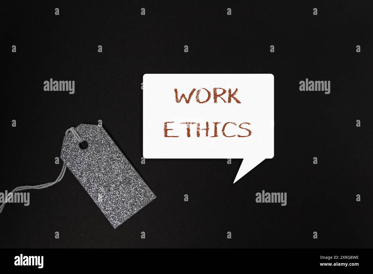Un tag con la parola etica del lavoro scritta sopra. Il tag è appeso su uno sfondo nero Foto Stock