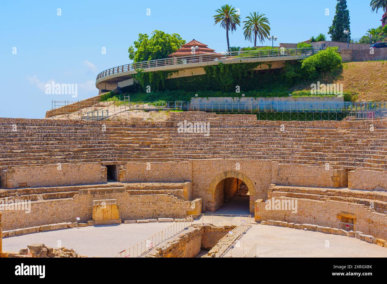 Le antiche rovine dell'anfiteatro di Tarragona mostrano imponenti strutture in pietra. Un mix di storia e modernità in contrasto con il vivace Mediterran blu Foto Stock