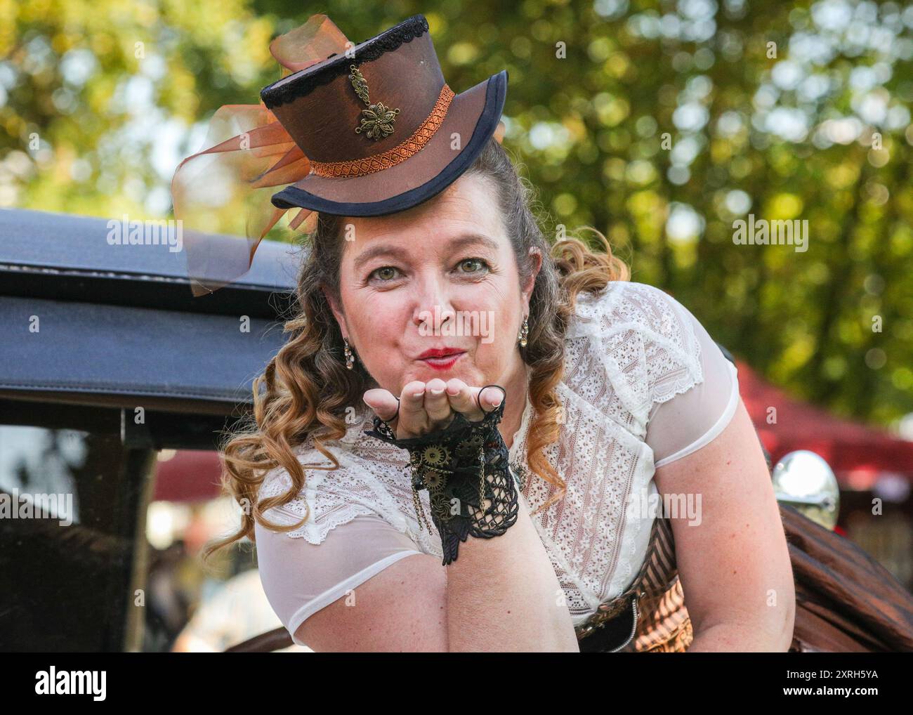 Henrichenburg, Waltrop, Germania. 10 agosto 2024. Un partecipante dà un bacio alla fotocamera. I fan dello steampunk, i gruppi e i visitatori, molti in costumi d'epoca retrò-futuristica o vittoriana, si divertiranno il primo giorno dell'annuale festival e mercato del Giubileo di Steampunk. Quest'anno, il festival coincide con il 125° anniversario dello storico impianto di risalita di Henrichenburg Boat Lift, sito patrimonio industriale lungo il canale Dortmund-EMS. Crediti: Imageplotter/Alamy Live News Foto Stock