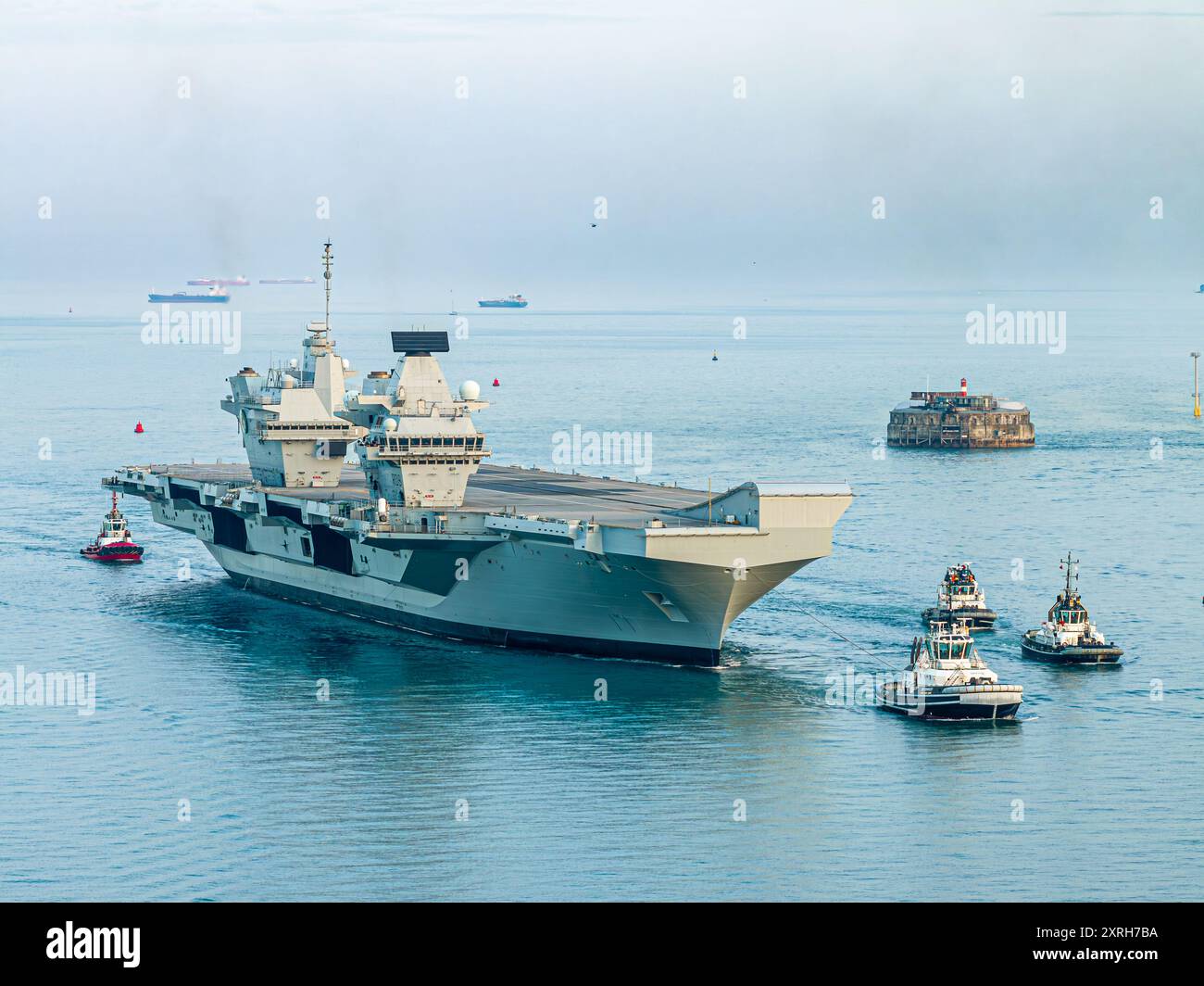 HMS Queen Elizabeth torna a Portsmouth dopo le riparazioni a Rosyth, in Scozia, che la causano la perdita della Steadfast Defender 2024 Foto Stock