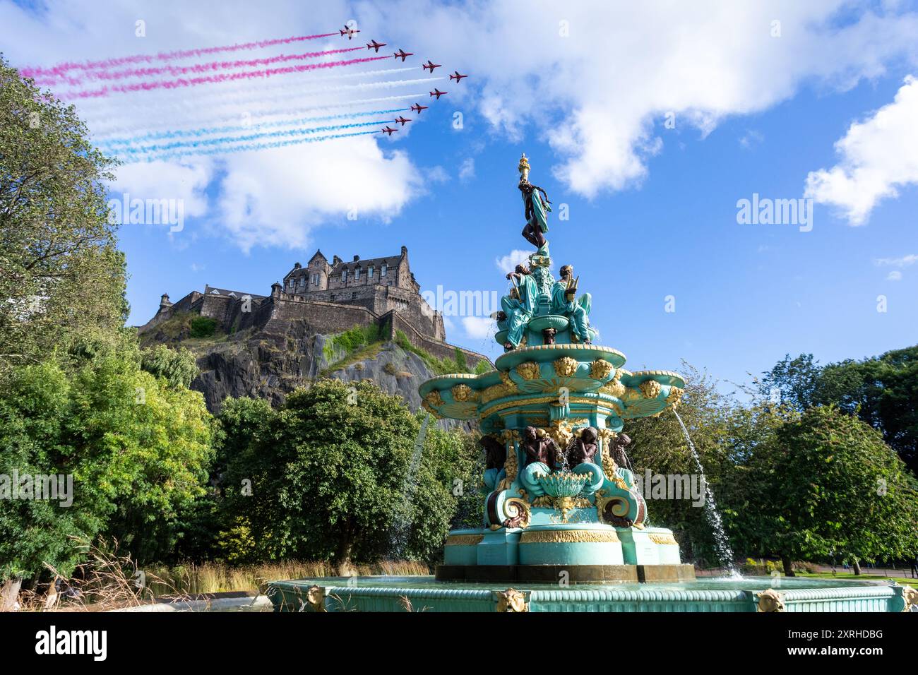 Edimburgo, Scozia, Regno Unito. 10 agosto 2024. Le frecce rosse sorvolano il castello di Edimburgo, visto dai Princes Street Gardens con la Fontana di Ross in primo piano. Crediti: David Coulson/Alamy Live News Foto Stock