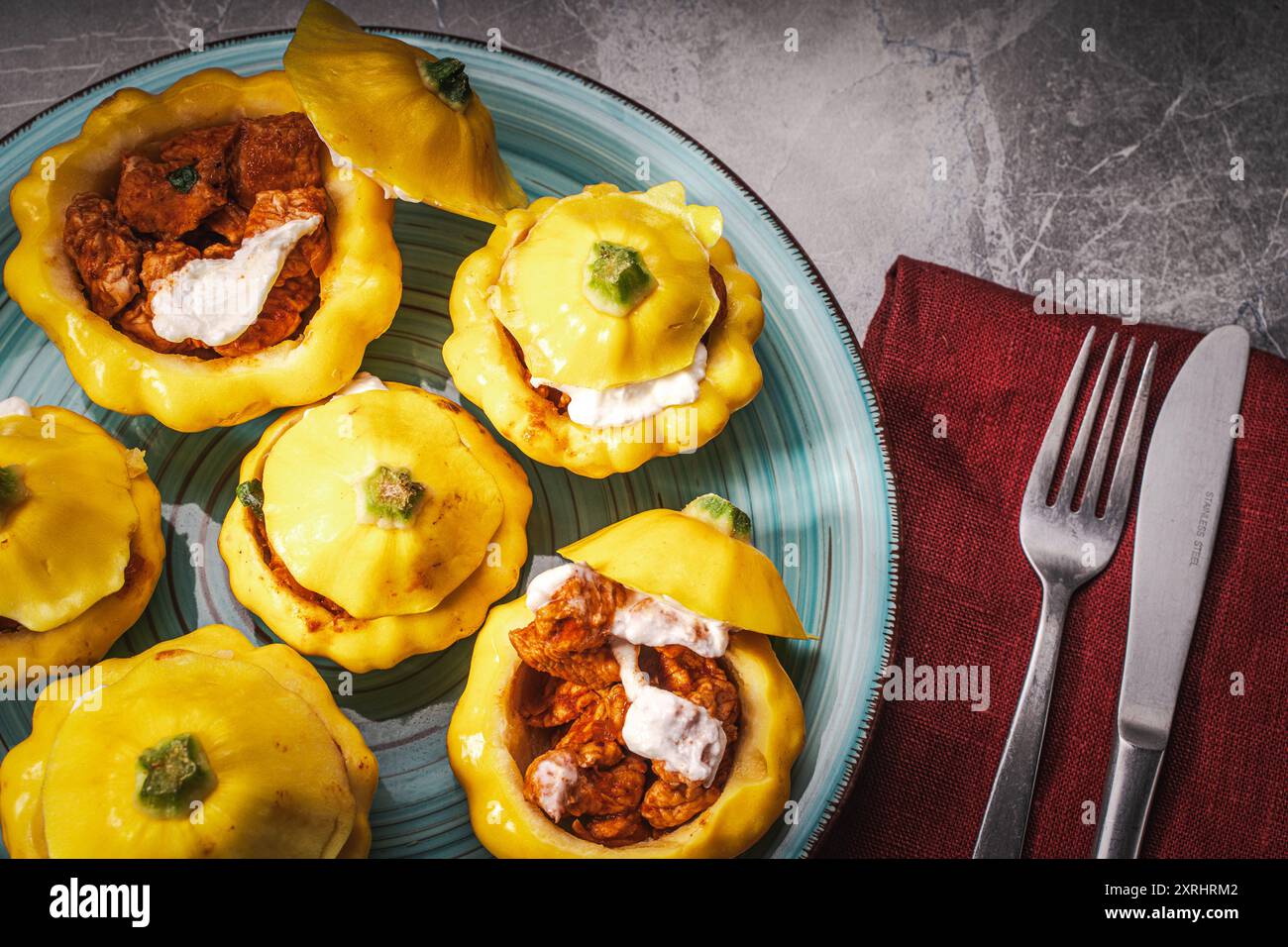 Tacchino cotto nella zucca con formaggio. Alcune zucche ripiene su un piatto turchese. Primo piano. Foto di alta qualità Foto Stock