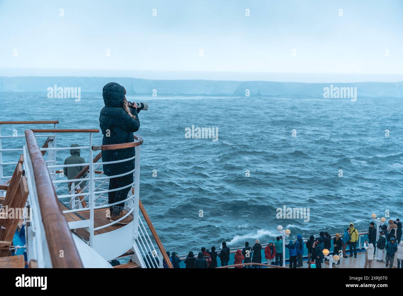 Antartide - 26 dicembre 2023 - foto di A23a Iceberg dalla nave da crociera dietro folla. Fotografie dei passeggeri dalla fotocamera della scalinata Foto Stock