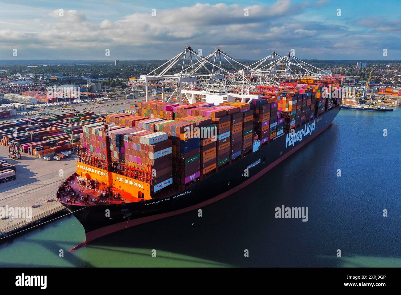 Southampton, Hampshire, Regno Unito. 10 agosto 2024. Vista aerea generale dei Western Docks al porto di Southampton, nell'Hampshire, con la nave container Hapag-Lloyd Damietta Express attraccata che porta il messaggio "Un futuro più pulito per la spedizione". Dopo il porto di Felixstowe, Southampton è il secondo terminal container più grande del Regno Unito, gestiva un traffico di 1,5 milioni di unità equivalenti (TEU). Crediti fotografici: Graham Hunt/Alamy Live News Foto Stock