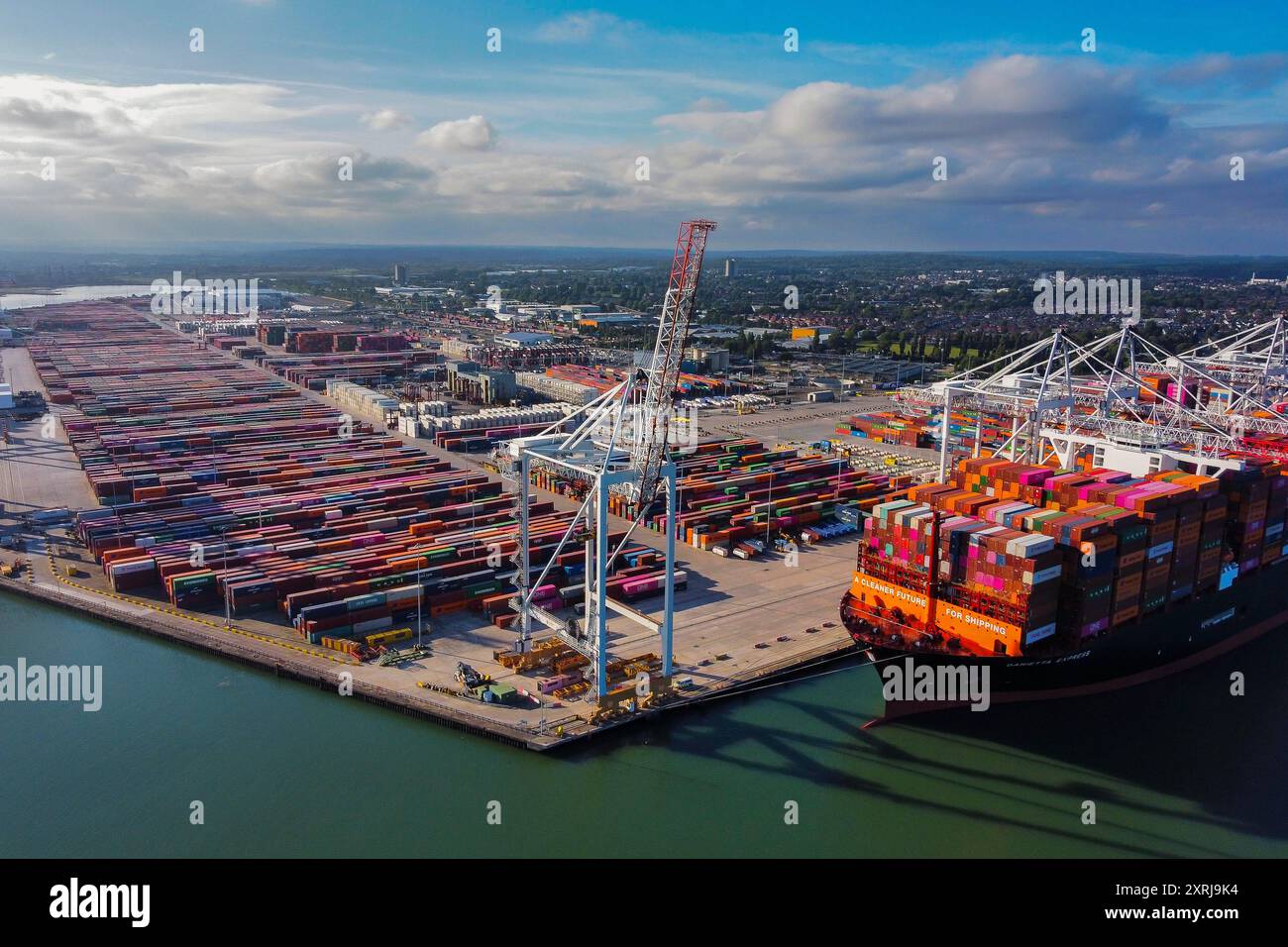 Southampton, Hampshire, Regno Unito. 10 agosto 2024. Vista aerea generale dei Western Docks al porto di Southampton, nell'Hampshire, con la nave container Hapag-Lloyd Damietta Express attraccata che porta il messaggio "Un futuro più pulito per la spedizione". Dopo il porto di Felixstowe, Southampton è il secondo terminal container più grande del Regno Unito, gestiva un traffico di 1,5 milioni di unità equivalenti (TEU). Crediti fotografici: Graham Hunt/Alamy Live News Foto Stock