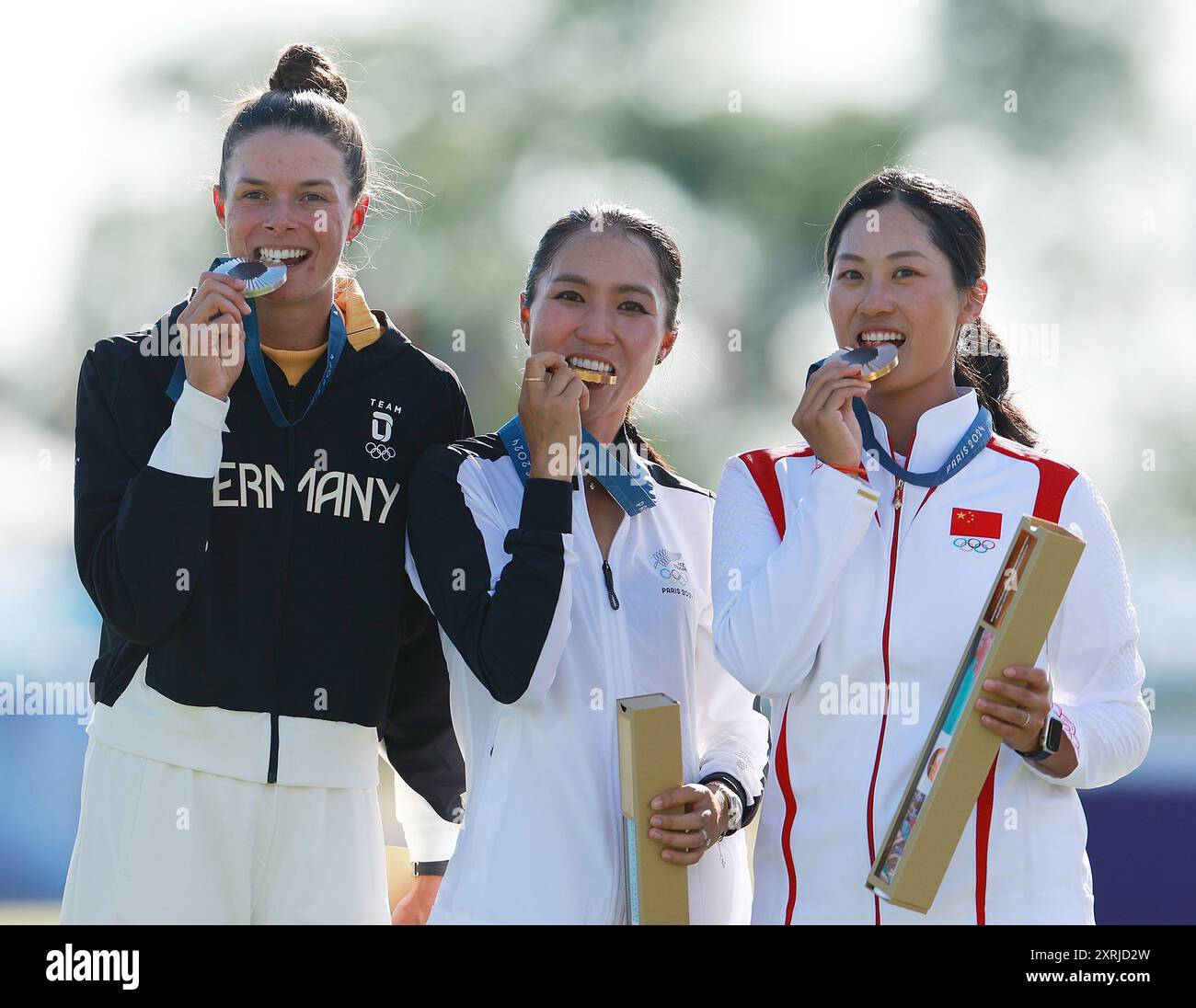 Saint Quentin EN Yvelines. 10 agosto 2024. La medaglia d'oro Lydia Ko (C) della nuova Zelanda, la medaglia d'argento Esther Henseleit (L) della Germania e la medaglia di bronzo Lin Xiyu della Cina hanno morso le loro medaglie durante la cerimonia di vittoria per il golf individuale femminile giocata ai Giochi Olimpici di Parigi 2024 a Saint-Quentin-en-Yvelines, Francia, 10 agosto 2024. Crediti: Ren Zhenglai/Xinhua/Alamy Live News Foto Stock