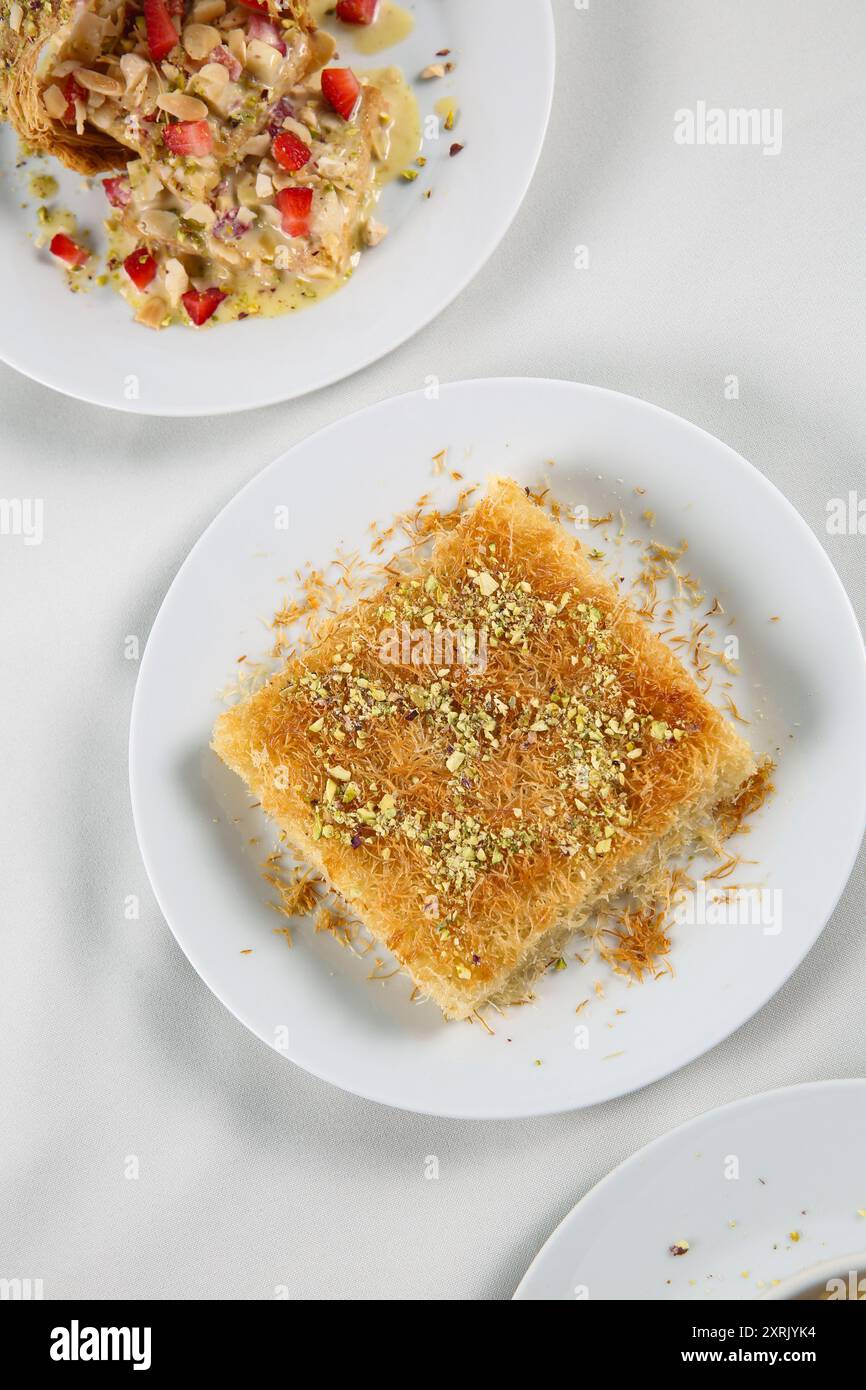 Kunefe arabo da dessert, kunafa, kadayif con pistacchio in polvere e formaggio, servito caldo, molto dolce. Dolce tradizionale turco. Dessert libanese di Kunaf Foto Stock