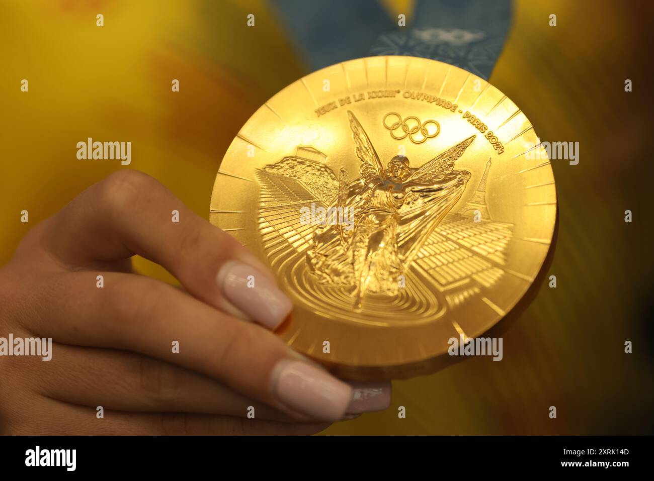 Otopeni, Romania - 7 agosto 2024: Dettagli con le mani di un atleta rumeno che detiene una medaglia d'oro vinta alle Olimpiadi di Parigi 2024. Foto Stock