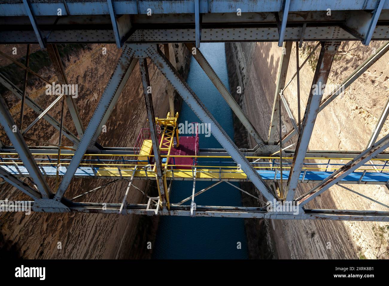 Vista dall'alto del Canale di Corinto, che mostra la struttura del ponte in metallo e lo stretto canale che taglia attraverso ripide scogliere in Korinthia, Grecia Foto Stock