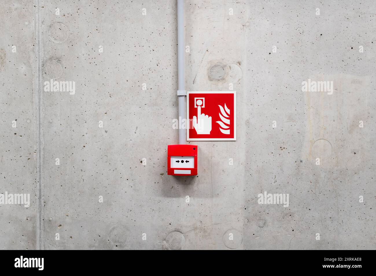 Pulsante rosso allarme antincendio. Parete in cemento. Allarme di emergenza. Foto Stock