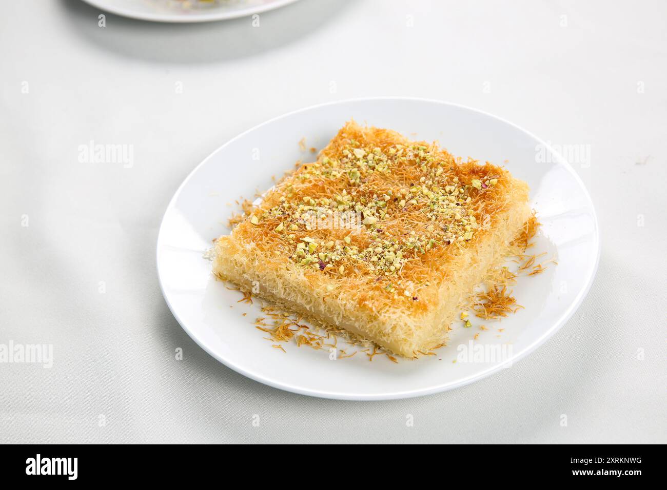 Dolci tradizionali arabi fatti in casa kunafa o noci knafeh sulla parte superiore, formaggio e sciroppo di zucchero, sul vassoio Foto Stock