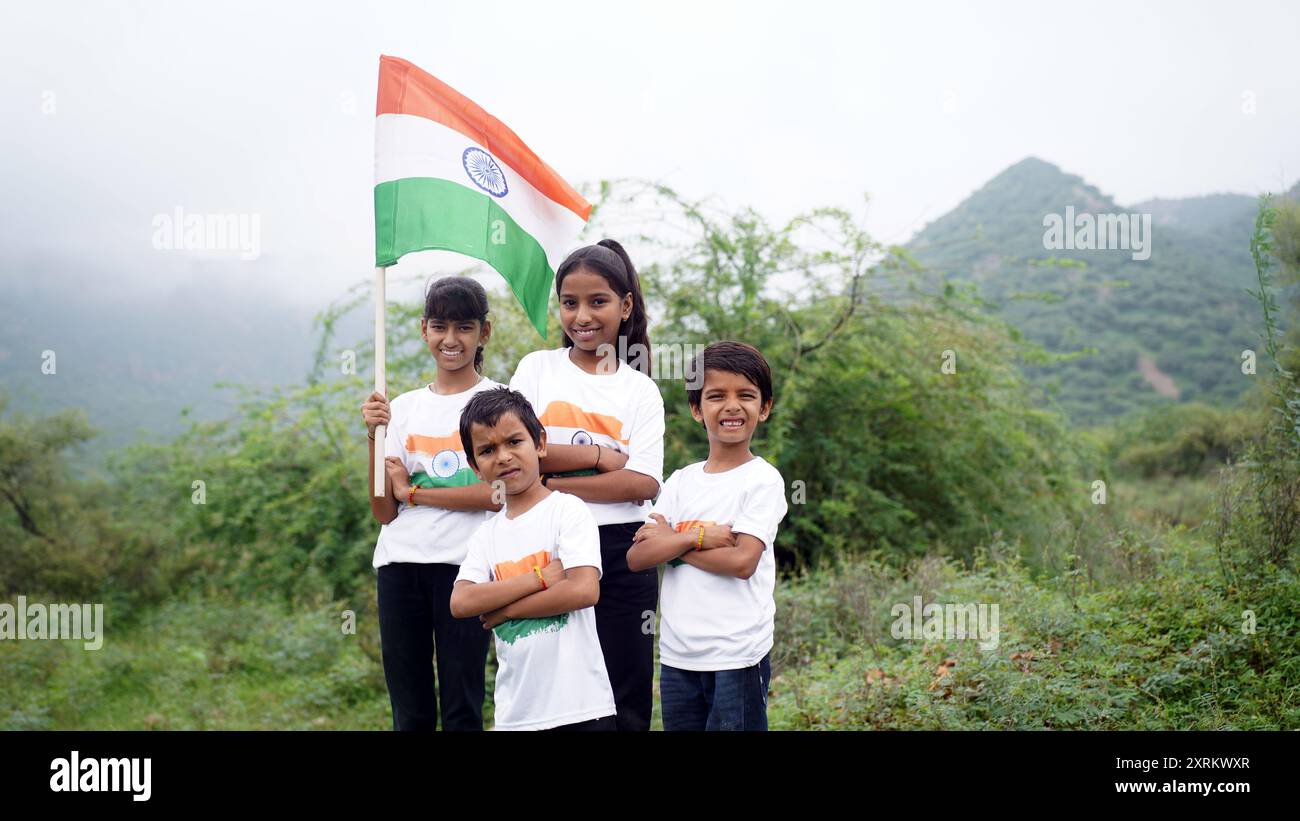 Gruppo di studenti o bambini che indossano una maglietta tricolore indiana, volto dipinto con triclolor e saluto. Festeggiamo l'indipendenza o il giorno della Repubblica. Har Ghar Foto Stock