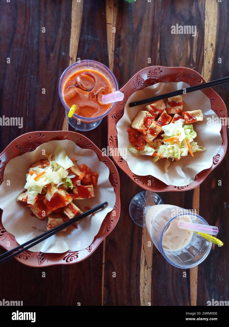 Primo piano di un delizioso tofu puzzolente e puzzolente con un piatto marrone di ravanello sottaceto fresco. spuntini di strada comunemente disponibili nei mercati notturni o nelle bancarelle lungo la strada Foto Stock