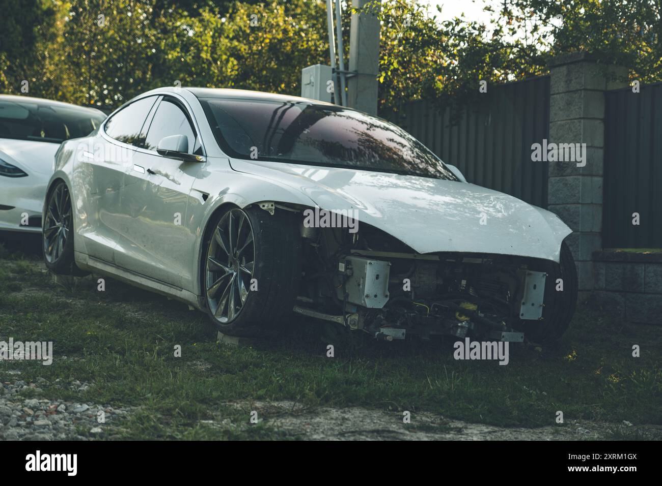 Un'auto elettrica rotta, senza fari, si trova nel villaggio Foto Stock