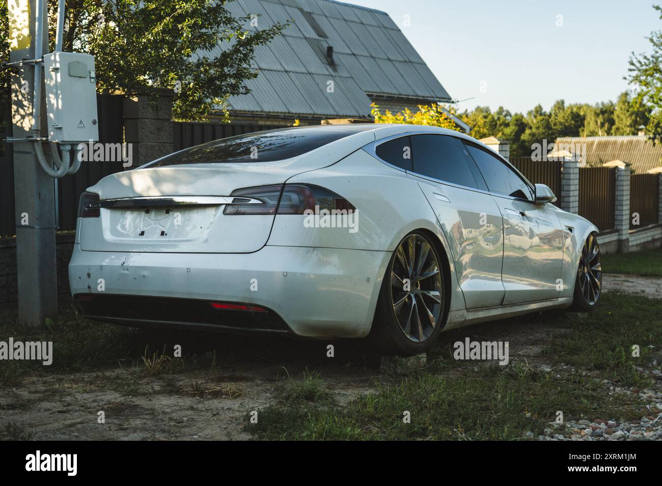 Un'auto elettrica rotta, senza fari, si trova nel villaggio Foto Stock