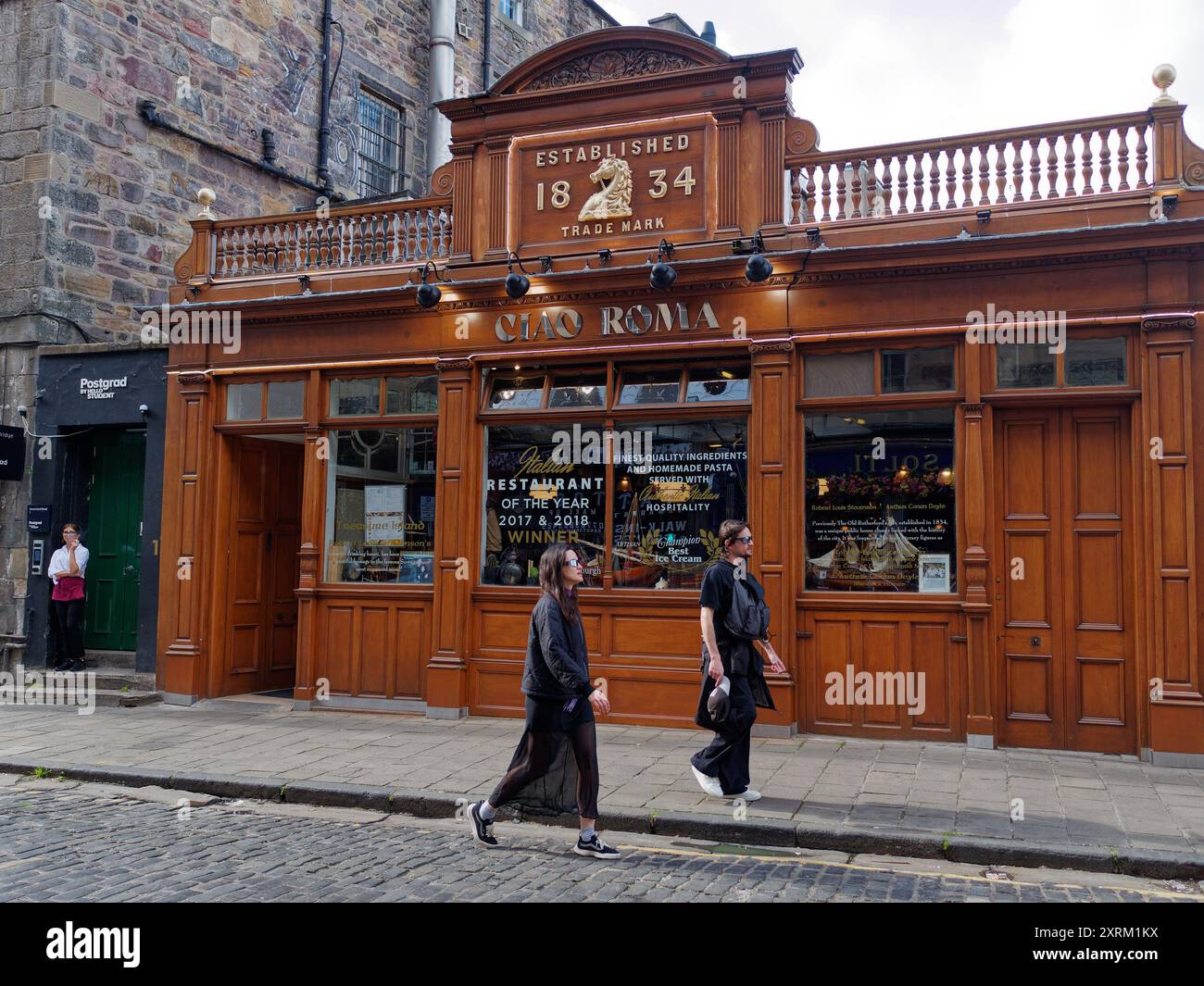 Passeggia per la coppia gotica davanti al ristorante Ciao Roma, fondato nel 1834 e frequentato da Robert Louise Stephenson. Edimburgo, Scozia, 10 agosto 2024 Foto Stock