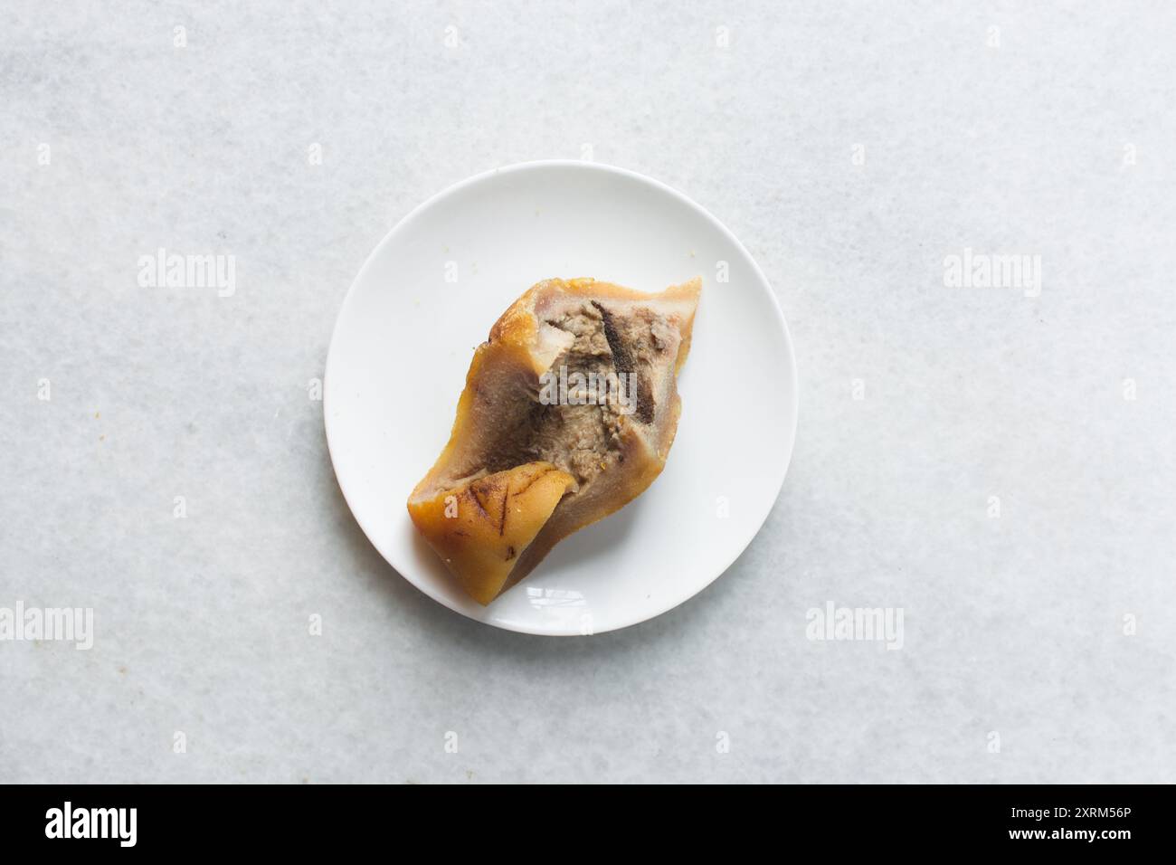 Vista dall'alto del kpomo nigeriano su un piatto bianco, vista dall'alto della pelle di mucca pulita per cucinare su un piatto Foto Stock