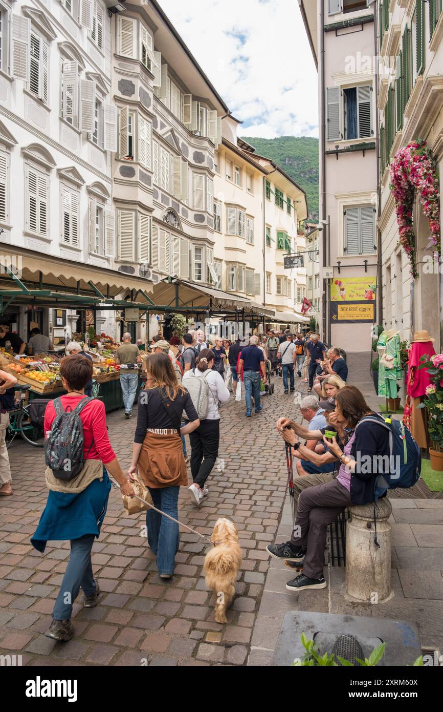 Varie persone in un antico vicolo del centro storico di Bolzano in Italia. Foto Stock