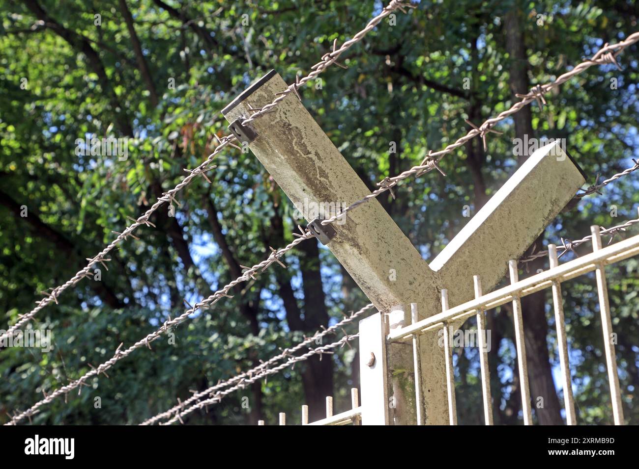 Zäune aus massiven materiale Ein unbeschichteter Stahlmattenzaun mit Stacheldraht am oberen Ende als Schutz an einem Gewerbegebiet *** recinzioni in materiale solido recinzione in rete di acciaio non rivestito con filo spinato nella parte superiore come protezione in una zona industriale Foto Stock