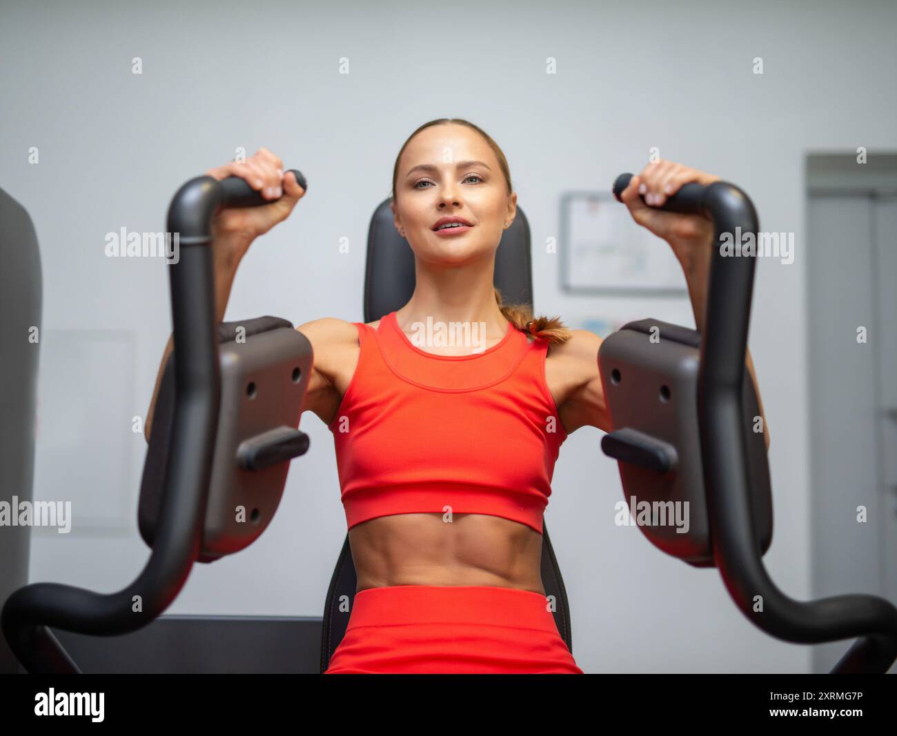 Donna che allena il petto in palestra, bodybuilding femminile e fitness Foto Stock