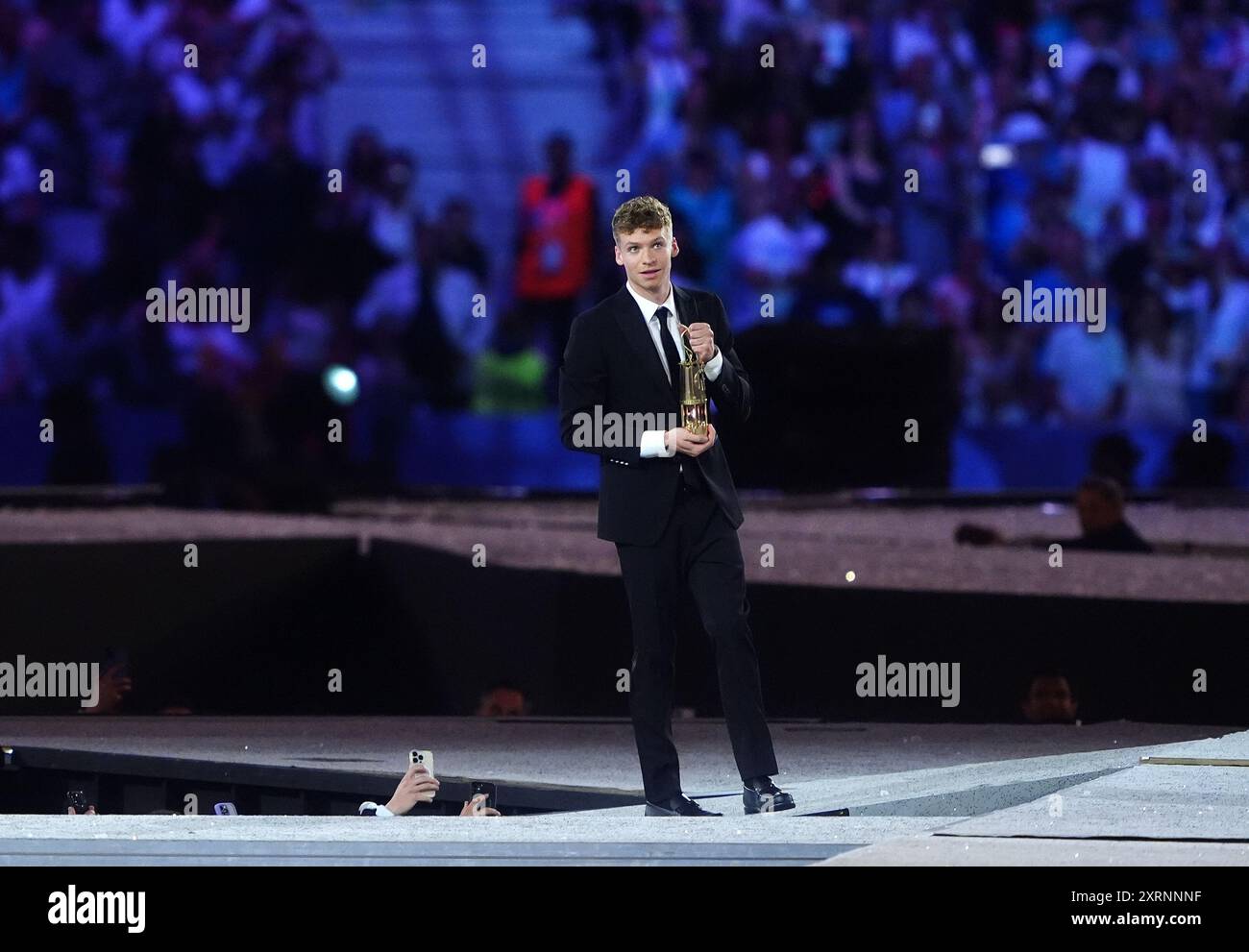 Il francese Leon Marchand arriva con la fiamma olimpica durante la cerimonia di chiusura dei Giochi Olimpici di Parigi del 2024, allo Stade de France di Parigi. Data foto: Domenica 11 agosto 2024. Foto Stock