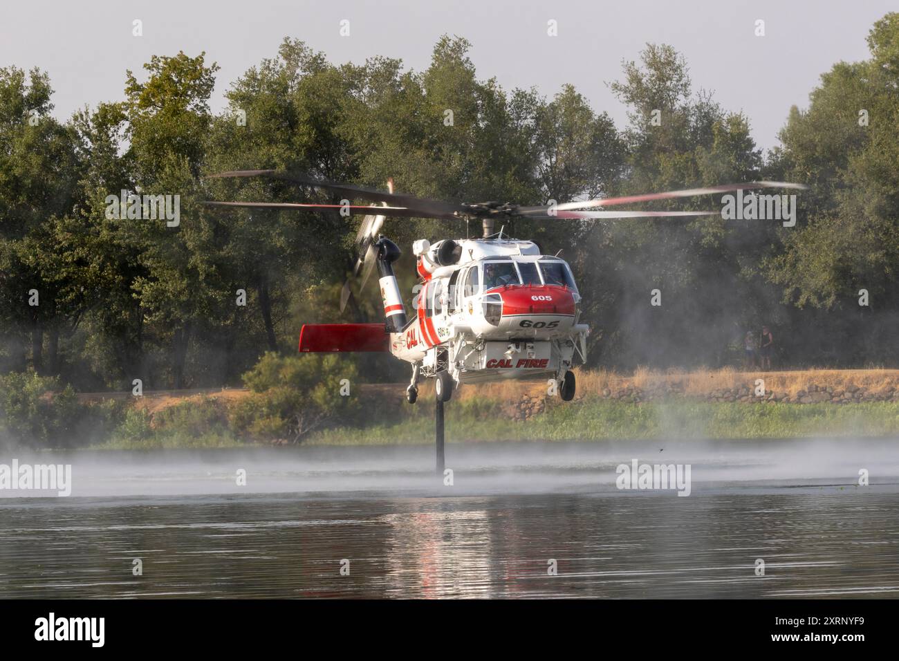 REDDING CALIFORNIA – 10 AGOSTO 2024 – Un elicottero CALFIRE Sikorsky S-70 “Firehawk” che pompava acqua dal lago Mary per combattere il vicino Lower Fire. Foto Stock